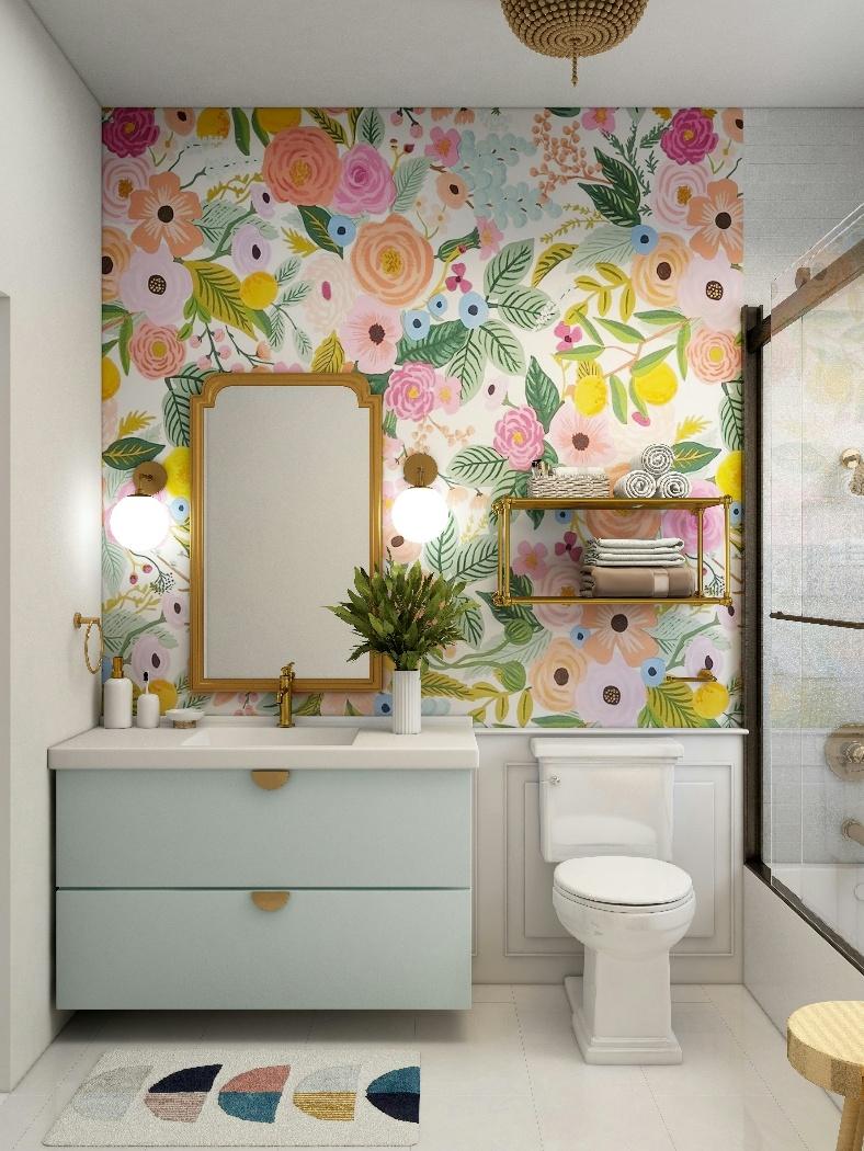 Lavabo pequeno decorado com papel de parede floral, tapete, arandelas e móveis planejados.